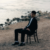 Artist Eden sitting on chair at beach